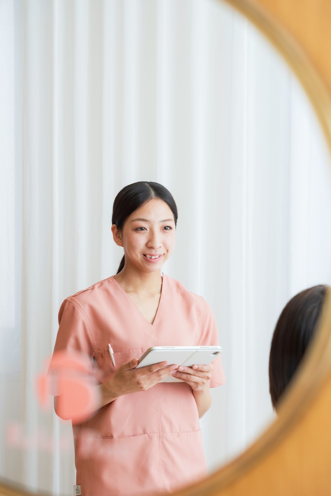 タブレットを持ち、やわらかく微笑む院長 豊嶋莉彩